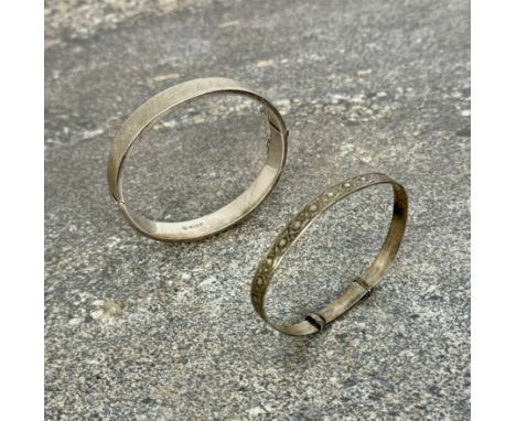Two silver bangles - one with engine turned bark effect finish, Birmingham 1968; the other stamped 'Sterling Silver', with fo