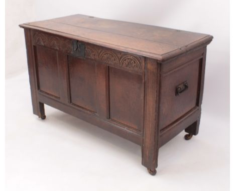 An early 18th century carved oak three-panel coffer - the moulded top on the original split-pin hinges, the interior with til