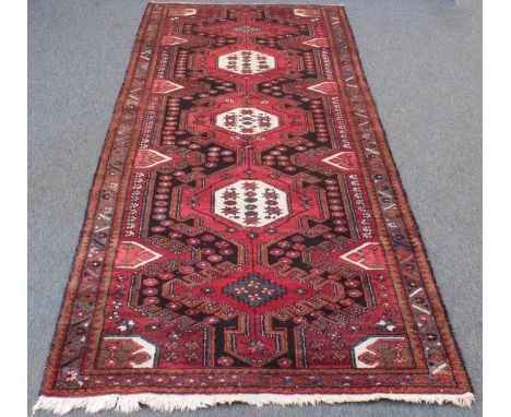 A Persian Hamadan hand knotted corridor rug - second half 20th century, with three ivory, grey-blue and red lozenge pole meda