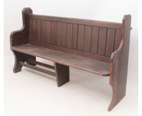 An early 20th century stained pine pew - (see lot 409) for a matching pew, with tongue-and-groove style back with shelf to re