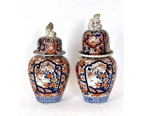 A pair of Japanese Imari porcelain jars - late 19th century, lobed ovoid form with domed covers with fo dog finials (one orig