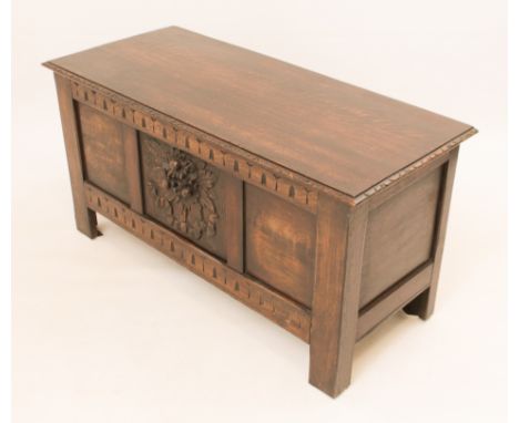 A three-panel oak chest in 17th century style - mid-20th century, the single-plank moulded top with carved border decoration,