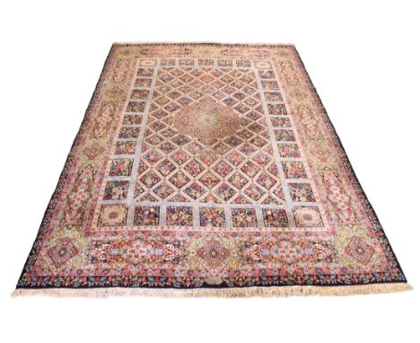 A Persian Qum style hand knotted wool carpet - mid-20th century, signed to border at one end, the central floral-style pendan