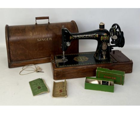 A Singer table-top sewing machine in original wooden case (with key) complete with bobbins, three user instructions and acces