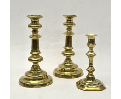 A pair of early 19th century brass candlesticks - with turned stems, on a bell-shaped circular foot, 23.3 cm high; together w