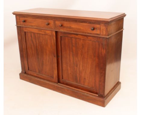 A mid-19th century mahogany side cabinet - the moulded top over two frieze drawers with turned handles, over two panelled sli