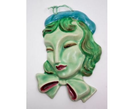 Clarice Cliff - A Large pendant face mask. Moulded as a young lady in profile with large bow collar and beret style hat.
Deco