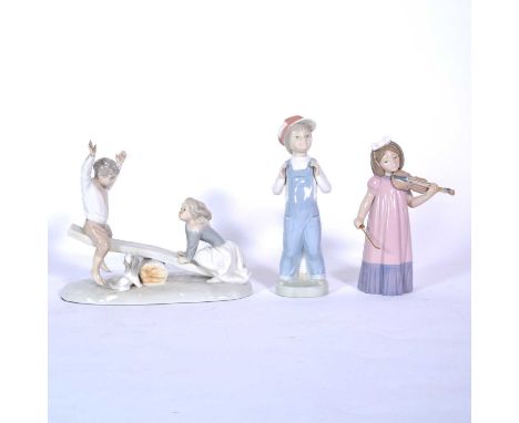 A Nao figurine of a girl violinist, 18.5cm; a Nao figural group depicting a boy and girl on a seesaw, 19.5x23cm; and a Lladro