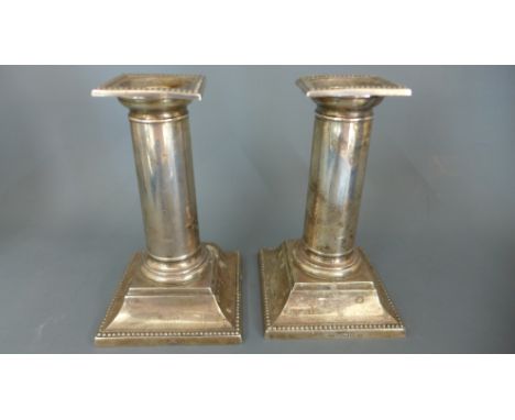 A pair of weighted silver candlesticks - Height 13cm - Sheffield 1899/1900 - maker R M E H - some bending to tops but general