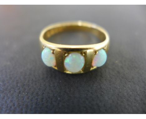 An 18ct yellow gold three stone opal ring - size R/S - Weight approx. 5 gs - centre opal 6mm x 4mm Condition report: Opals li