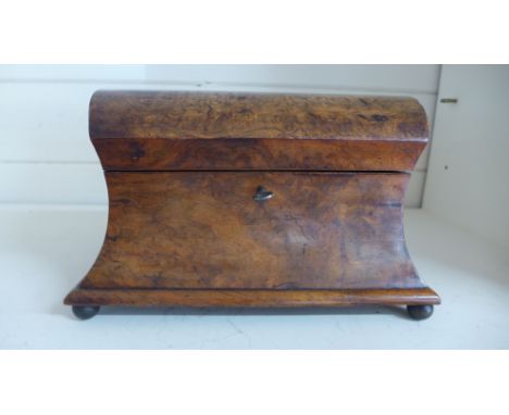A walnut sarcophagus shaped tea caddy with dome top raised on bun feetCondition report: In good order, some slight loss to ve