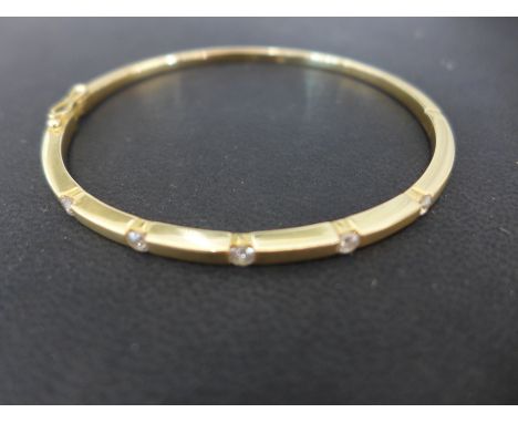 An 18ct yellow gold five stone diamond bangle - 65mm x 57mm - Weight approx. 16gms Condition report: In good condition, stone