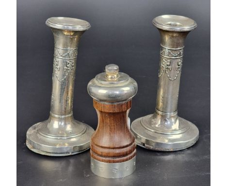 A silver pepper grinder, by David Shaw Silverware Ltd, London 1981, 10.5cm high; together with a pair of silver candlesticks.