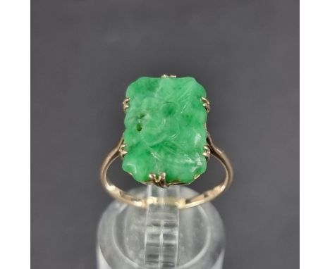 A yellow metal ring, set carved and pierced jade panel, stamped 9ct, size O.