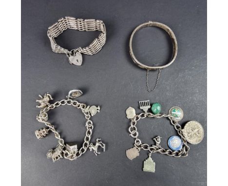 Three silver bracelets, comprising: a silver charm bracelet, with seven silver and one metal charm attached; another silver c