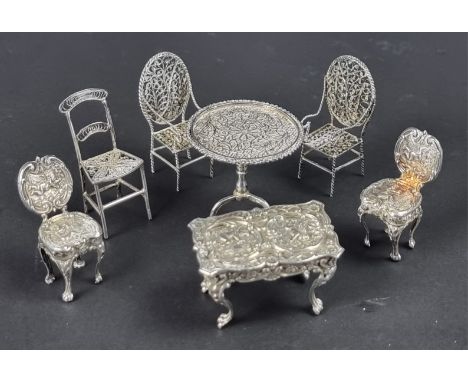 A miniature silver novelty table and pair of chairs,&nbsp;23g; together with a similar Chinese miniature tripod table; and th