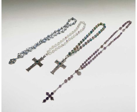 A rosary with carved amethyst beads and amethyst set silver cross, two chased silver crosses each with opal chips and a blue 