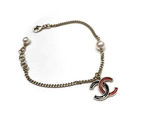 Chanel braceletGoldtone chain with two faux pearls and suspended CC logo pendant enamelled in black and red. Lobster claw cla