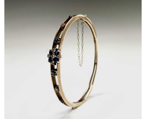 A 9ct gold diamond and sapphire bangle 50x58mm 11.4gm Birmingham 1988Condition report: Good used condition, hinge and clasp w