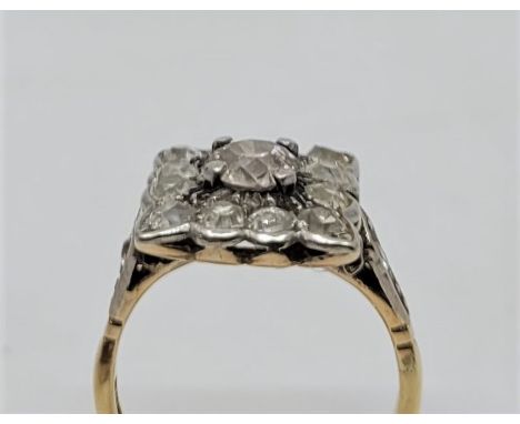 An 18ct. gold and diamond cluster ring, with central cushion-cut diamond and twelve pave set surrounding old-cut diamonds, (e