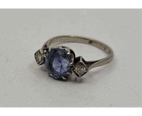 An 18ct. white gold, platinum, sapphire and diamond ring, claw set mixed oval cut sapphire to centre, with a lozenge shape mo