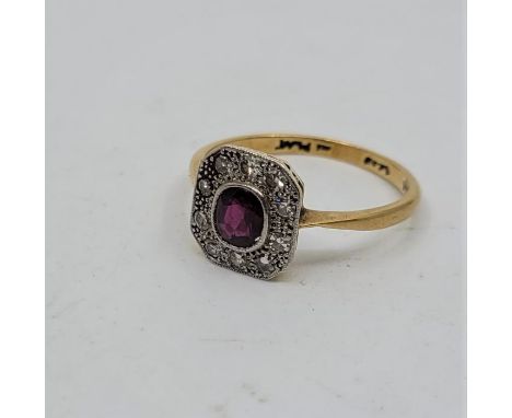 An Art Deco 18ct. gold, platinum, ruby and diamond ring, having central mixed cushion cut ruby in rub-over setting bordered b