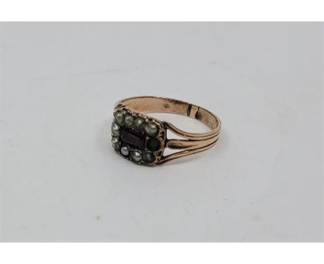 A Victorian precious yellow metal, ruby and pearl set ring, set central mixed cut ruby bordered by pearls, with ribbed band (