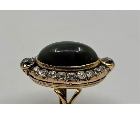 A 22ct. gold, cats eye chrysoberyl and diamond ring, of navette form, having large oval cabochon green cats eye chrysoberyl i