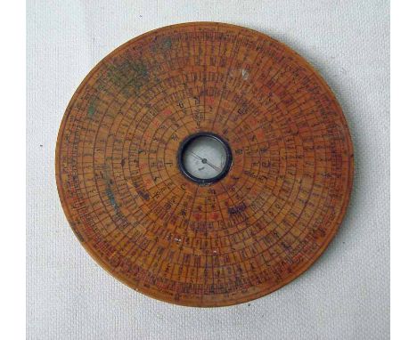 A Chinese lacquered wooden geomancers compass, circular with inset central silvered compass surrounded by bands of text and c