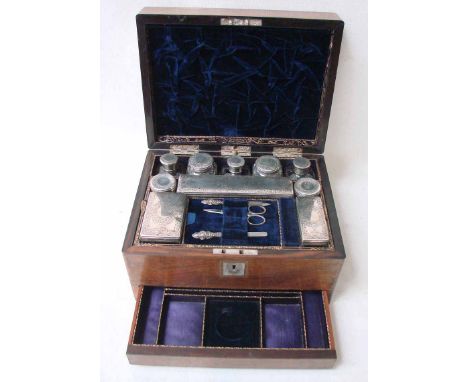 An early Victorian rosewood ladies travelling box, the hinged cover with mother of pearl inlaid cartouche opens to reveal a f
