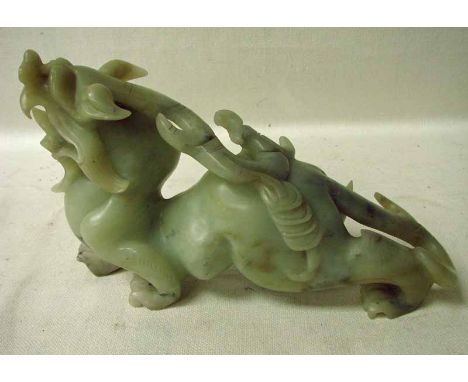 A Chinese carved jade sculpture depicting a mythical dragon dog with a scorpion on its back, 29cm long 