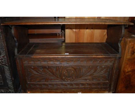 An early 20th century line relief carved oak fold-over monks bench, having typical hinged box seat base, width 106.5cm