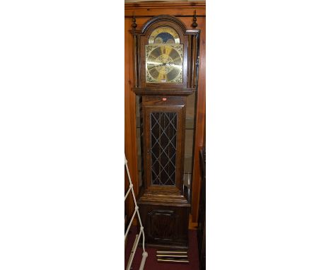 A contemporary oak longcase clock by Fen Clocks of Suffolk having an arched moon phase brass dial, lead glazed trunk door, wi