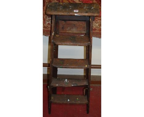 A rustic stained pine five-step A-frame decorators ladder