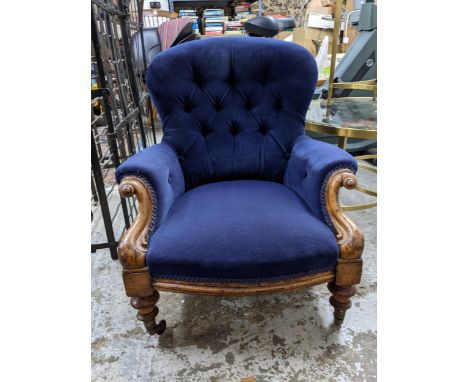 A Victorian walnut framed upholstered nursing chair, blue button back upholstery, turned front legs on ceramic castors Locati