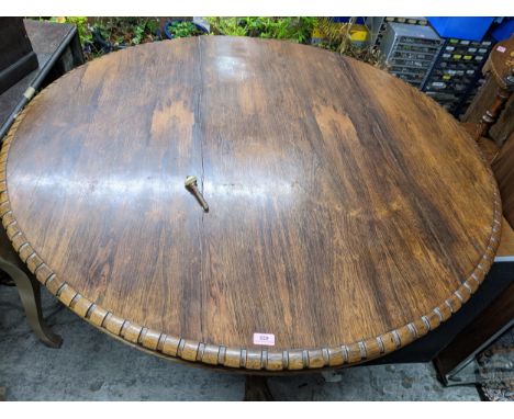 A Regency/early Victorian rosewood tilt top breakfast table, circular top with dentil moulded edge rim, over and turned and c