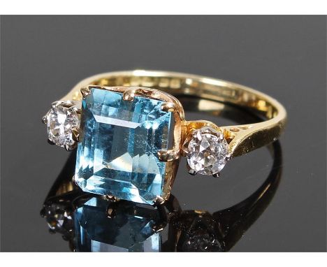 18 carat gold aquamarine and diamond ring, the central aquamarine at approximately 4 carats flanked by two diamonds, ring siz