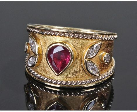 18 carat gold diamond and ruby ring, the pear cut ruby flanked by diamonds to form a leaf edge on the tapered shank, ring siz