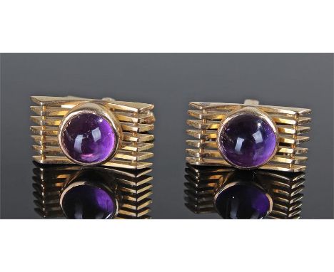 Pair of 14 carat gold amethyst set cufflinks, the cabochon amethyst set above seven arched pointed bands, 21mm high