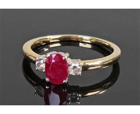 18 carat gold diamond and ruby ring, the central oval synthetic ruby flanked by a pair of diamonds, ring size R