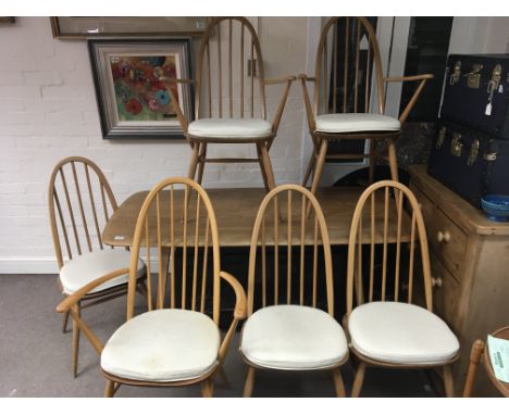 A modern design Ercol dinning table with a set of seven light wood beech and Elm chairs hoop backs with pad cushions attached