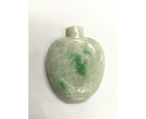 A carved jade snuff bottle decorated with a crane amongst foliage to one side and a junk to the other side, approx 6cm.