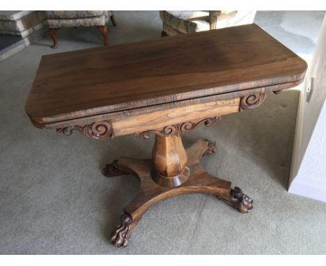 An Early Victorian Rosewood card table. the twin flap top on a shaped column and elaborate platform base.