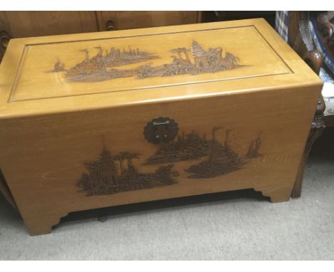 A large carved camphor wood trunk with a rectangular hinged top.