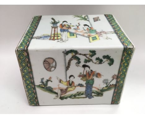 An Oriental ceramic pillow depicting various figures in a garden setting, approx width 22cm.