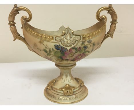 A Royal Worcester porcelain chase with raised gilded scroll handles and raised embellishments hand painted with flowers and f