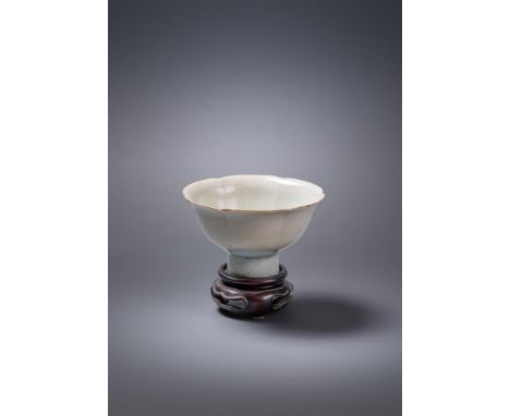A Chinese Qingbai stem cup, Song Dynasty, the rounded sides divided into six lobes, supported on a tubular stem, covered over