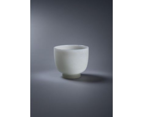 A Chinese white jade cup, Qianlong or Jiaqing, carved with deep sides rising from a short splayed foot, the translucent stone