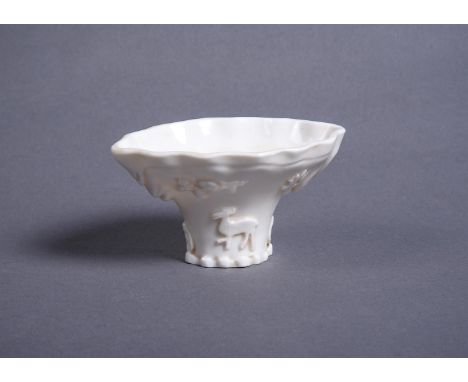 A Chinese Dehua libation cup, 17th or early 18th century, applied to one side with a deer and crane and the other with a drag