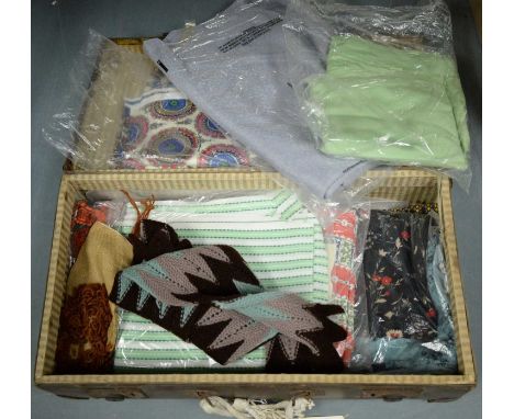 A selection of vintage fabric and textiles, including patterned and embroidered examples, contained together in a travel trun